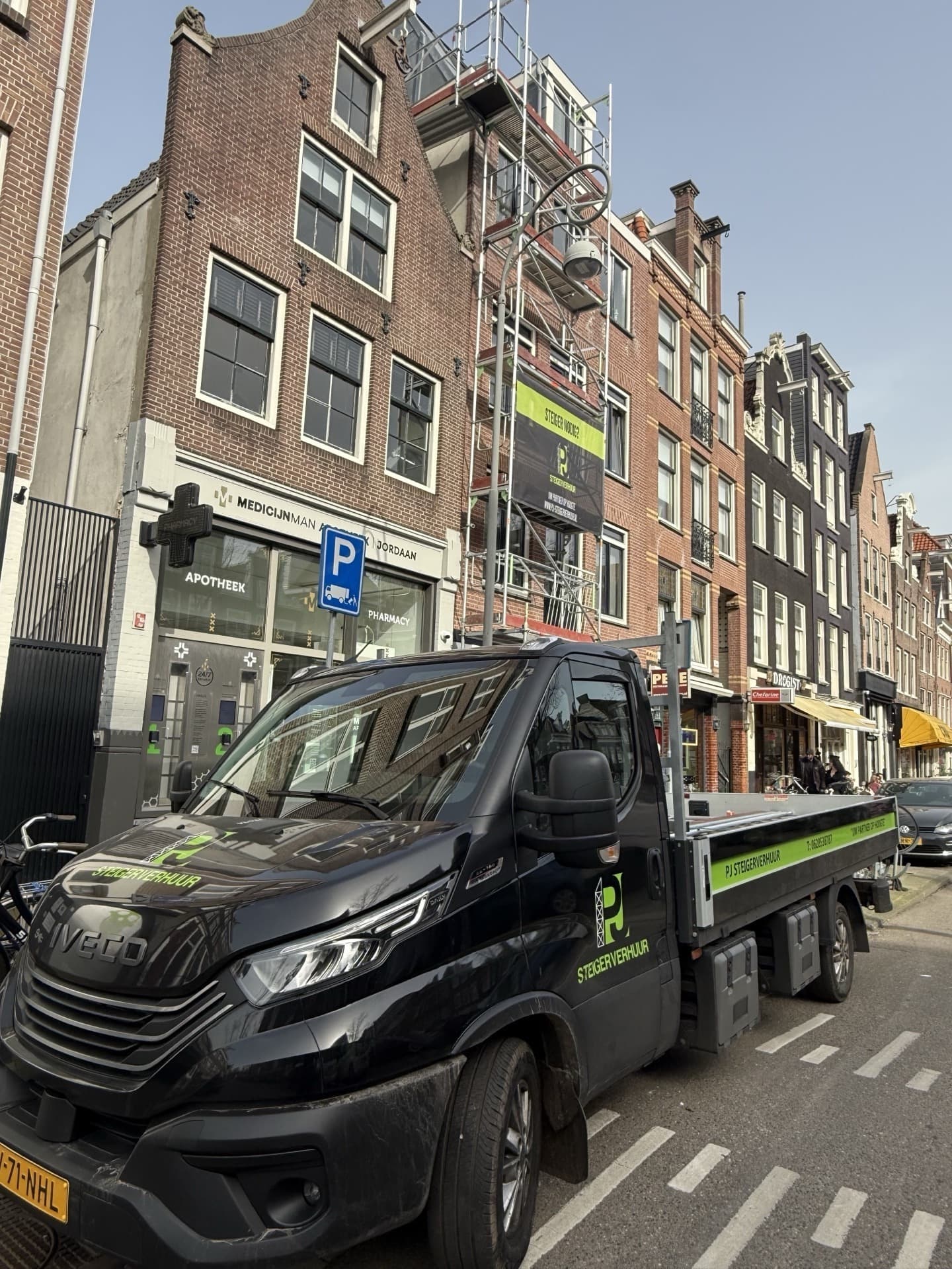 PJ Steigerverhuur bedrijfswagen bij gevelsteiger in Amsterdamse grachtenstraat