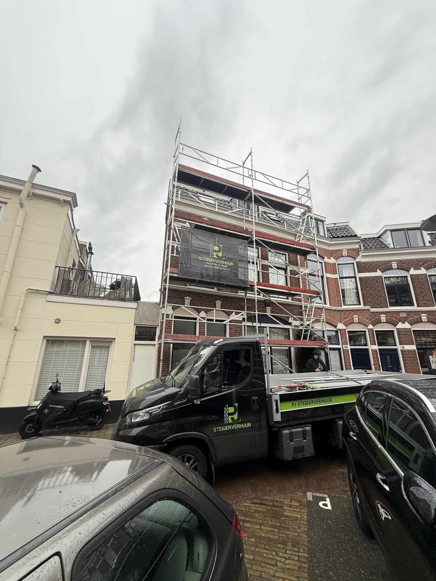 Steigerconstructie met PJ Steigerverhuur branding en bedrijfsbus op locatie