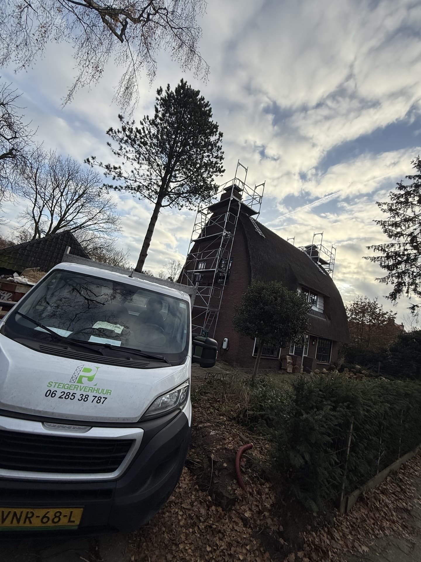 PJ Steigerverhuur bedrijfsbus met logo op locatie bij daksteiger project